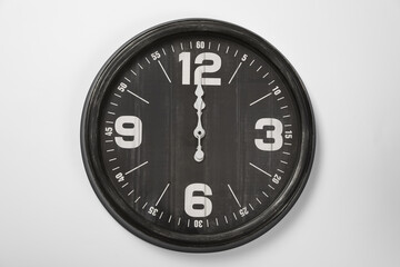 Stylish analog clock hanging on white wall