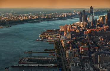 Obraz premium Sunset in New York, view from above. Amazing sun light over Manhattan and Hudson river during a sunset, images taken from the highest building in the city. Impressive architecture. Landmark of America