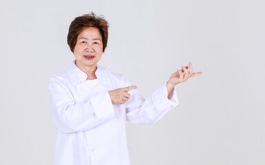 Elegant senior woman as professional chef confidently standing with arm crossed and wooden spoon and fork in restaurant kitchen