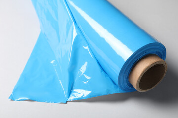 Roll of plastic stretch wrap film on white background, closeup