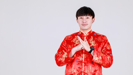 Smart chinese man on elegant red traditional mandarin shirt gesture for warm welcome greeting with...