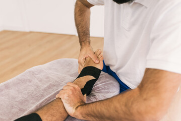 Close-up view of a professional therapist treating a patient foot. Physiotherapy and rehabilitation therapy concept.
