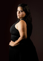 Fototapeta premium Modelo mujer con vestido negro y fondo negro
