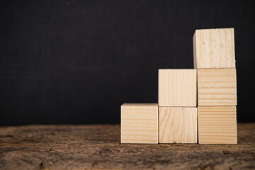 Stack of wooden block on wooden board background.