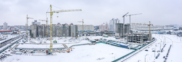 winter aerial panoramic view of large construction site in residential district