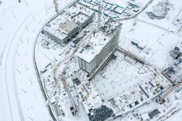 modern residential complex under construction. tower cranes at work. winter aerial view.