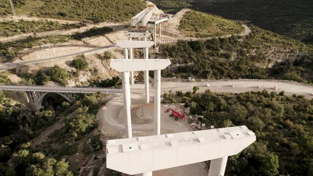 Drone footage from above of an unfinished bridge&acute;s structure under construction in Barranco de la Bota in Morella on a sunny afternoon