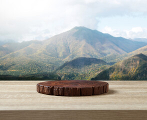 Wooden cuttingboard on table for standing product against nature landscape
