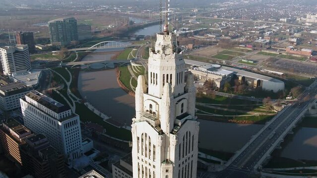 Aerial view in front of the sunlit Leveque Tower, in Columbus - descending, tilt, drone shot