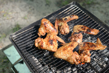 Grilled chicken wings, BARBECUE Chicken in hot sauce grilled on coals on the grill outdoors, picnic in the garden or in the backyard. Chicken BBQ