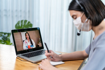 Fototapeta na wymiar Asian young woman video call with doctor in living room at home. 
