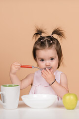 Kid eat healthy nutrition, baby food. Babies eating with spoon. Kid girl eating healthy food.