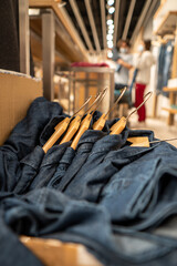 Denim shirts hanging inside a cardboard box in a clothing store