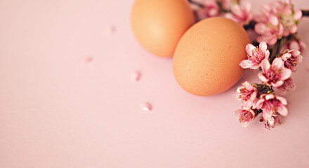 Naklejka na ściany i meble Easter eggs with spting flowers on pastel pink background