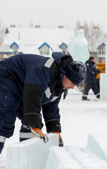 A worker loads ice blocks onto a sled