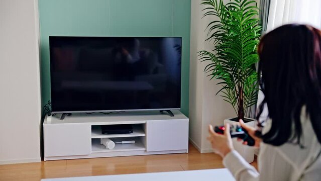 テレビゲームで遊ぶ女性