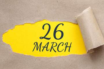 march 26. 26th day of the month, calendar date. Hole in paper with edges torn off. Yellow background is visible through ragged hole.Spring month, day of the year concept