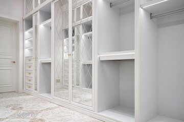 Luxury white walk-in closet with led lamps on shelves and mirror facades with rhombuses and...