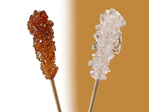 brown and white rock candy, sugar crystals on wooden stick isolated on two colored background