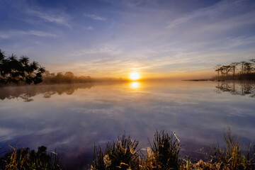 Sunrise over water with foggy at Wang Kwang Reservoir Phu Kradueng National Park, Loei province, Thailand