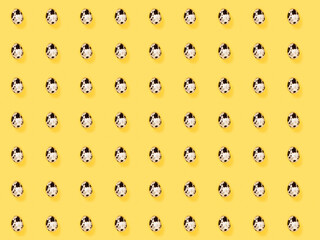 The easter background with the quail brown eggs pattern on the trendy yellow background.