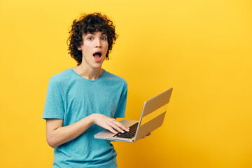 guy in blue t-shirts with laptop internet yellow background