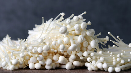 Close-up image of enoki mushrooms against a dark background.
