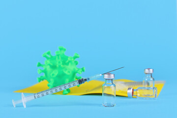 Vaccination against Corona concept with vials and syringes, vaccination passport, virus model and...