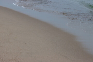 Fototapeta na wymiar Wet coastal sand.