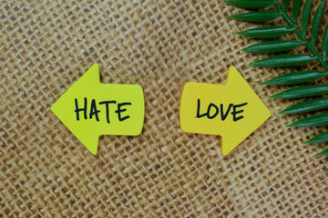 Hate or Love write on sticky notes isolated on Wooden Table.