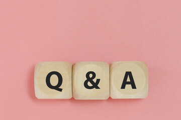 Q and A text on wooden cube block pink background. word question answer symbol. Question Ask...