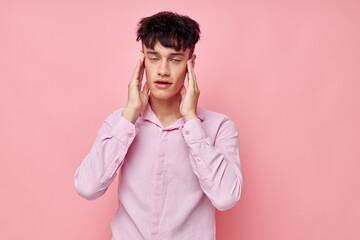 handsome guy gestures with hands emotions hairstyle fashion pink background unaltered