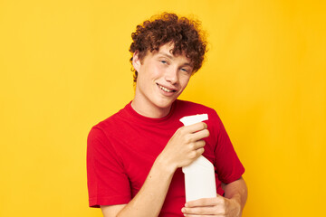 cute red-haired guy in a red t-shirt detergents in hands posing monochrome shot