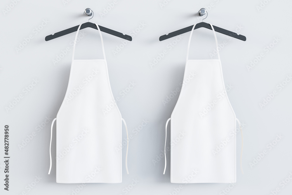 Poster empty white kitchen aprons on hangers. light background. chef and cooking concept. mock up place. 3d