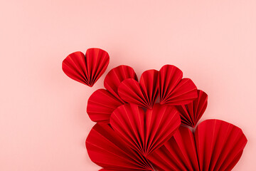 Red passion love hearts of chinese paper fans as group on pastel pink color -  Valentines day...