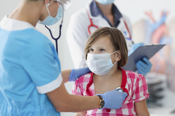 Pediatrician doctor with stethoscope listen little girl breath and heartbeat on appointment