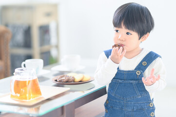 美味しそうにおやつを食べる幼児　コピースペースあり