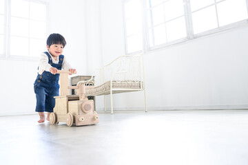木のおもちゃで笑顔で遊ぶ日本人の子供　広角　コピースペースあり