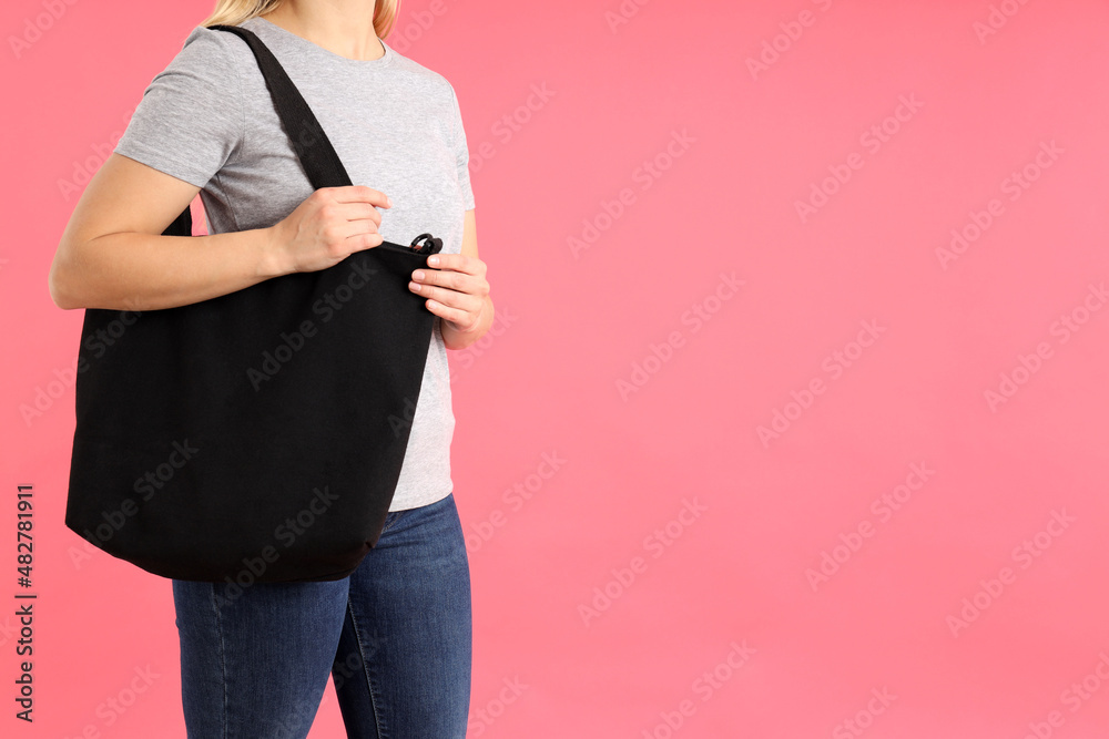 Poster woman in t-shirt with black bag on pink background