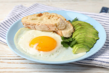 Plate of tasty breakfast on white wooden background