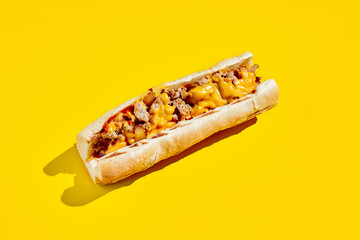 Chiken cheesesteak in minimal style. American fast food in yellow background with shadow. Philly steak sandwich trendy concept. Junk food in colour background.