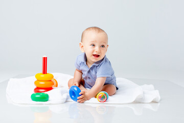 baby boy with a multi-colored pyramid is isolated on a white background;