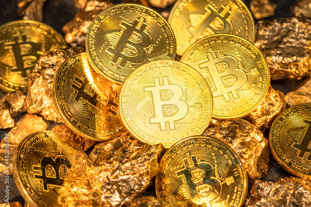 Wall mural bitcoins and pieces of gold closeup. bitcoin against gold, what is the more attractive asset?