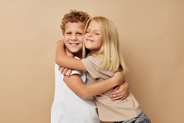 boy and girl in t-shirts hugs beige background friendship