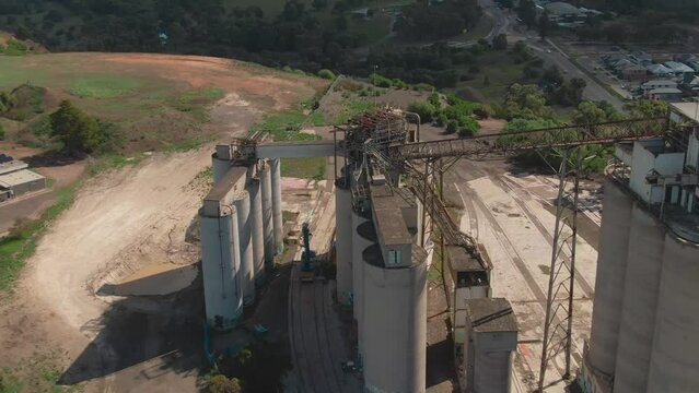 4k Aerial Painted grain silos with city in background Drone overhead medium shot
