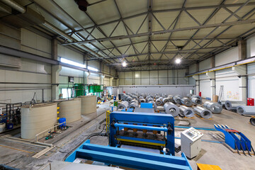 Production line of metal tile for roof. Steel forming machine in metalwork factory workshop