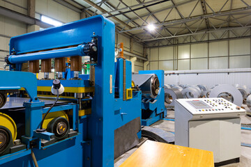 Photo of steel roofing forming machine. Industrial machine for metal sheet roof coils cut. Process of making steel tile for roof