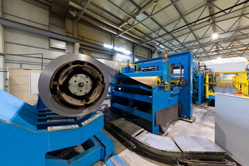 Photo of steel roofing forming machine. Industrial machine for metal sheet roof coils cut. Process of making steel tile for roof