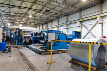 Photo of production line of metal tile for roof. Steel forming machine in metalwork factory workshop. Metal sheet profiling machine. Background of plant