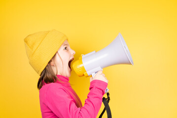 Angry little girl shouting loud on loudspeaker. Children rights concept.